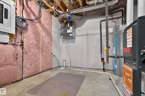 Unfinished basement area featuring exposed ceiling joists and ductwork, a utility panel, and a water heater - 1534 Plum Circle Circle Sw, Edmonton, AB - Indoor Photo Showing Basement
