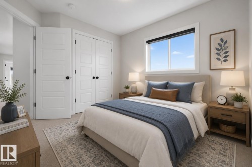 Carpeted bedroom featuring a large window, white trim, and multiple panel doors - 1534 Plum Circle Circle Sw, Edmonton, AB - Indoor Photo Showing Bedroom