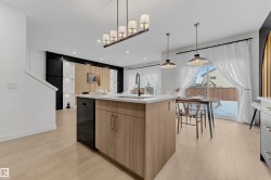 Spacious kitchen island featuring a waterfall countertop, integrated sink, and wood-finish cabinetry - 