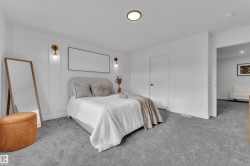 Bedroom featuring light gray carpeting, crisp white walls, and a recessed ceiling light fixture - 