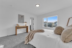 Bright interior space featuring a large window, recessed lighting, and grey carpeting - 