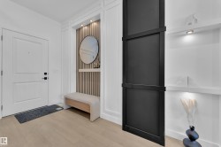 Entryway featuring light wood-finish flooring and a white paneled door with matte black hardware - 
