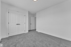 Room featuring white walls, gray carpeting, and white baseboards - 