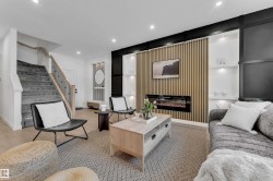 Integrated living area featuring a modern electric fireplace with a wood-slat accent wall, built-in shelving with recessed lighting, a carpeted staircase with wood handrails and metal balusters, and wood-finish flooring - 
