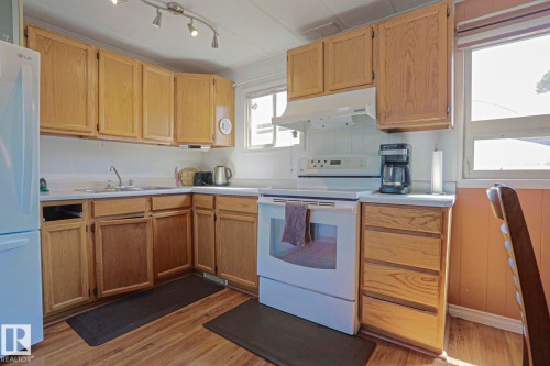 Kitchen featuring wood-finish flooring, light wood cabinetry, white countertops, a white electric range, and a white refrigerator - 137 Lee Ridge Road Nw, Edmonton, AB - Indoor Photo Showing Kitchen With Double Sink