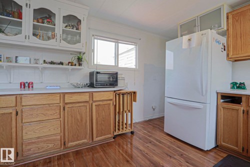 Kitchen featuring wood-finish flooring, white countertops, and both light wood base cabinetry and white upper cabinets - 137 Lee Ridge Road Nw, Edmonton, AB - Indoor Photo Showing Kitchen