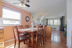 Dining area featuring wood-finish flooring, a ceiling fan, and a double window - 