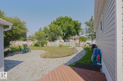Spacious backyard featuring a large paver patio, a curved paver walkway, and a privacy fence - 