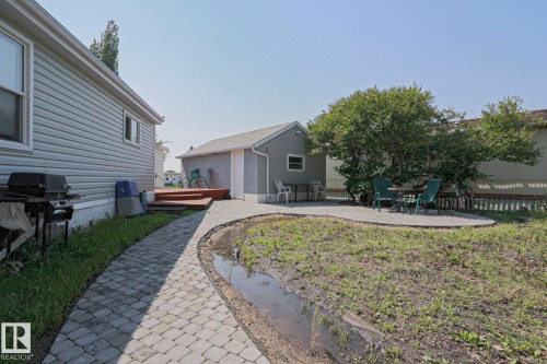 Exterior featuring light-colored siding, a paved walkway, and a wooden deck - 137 Lee Ridge Road Nw, Edmonton, AB - Outdoor