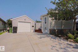 Detached garage with a single vehicle door and textured stucco siding - 
