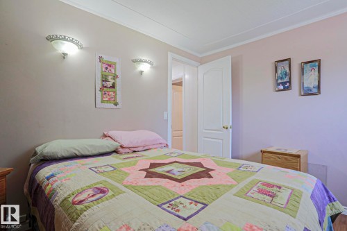 Bedroom featuring neutral-toned walls, crown molding, and wall-mounted sconces providing ambient lighting - 137 Lee Ridge Road Nw, Edmonton, AB - Indoor Photo Showing Bedroom