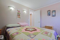 Bedroom featuring neutral-toned walls, crown molding, and wall-mounted sconces providing ambient lighting - 