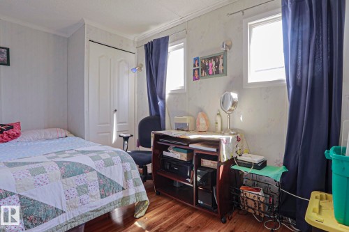 Interior space featuring wood-finish flooring, two windows, and a built-in closet with a white paneled door - 137 Lee Ridge Road Nw, Edmonton, AB - Indoor Photo Showing Bedroom