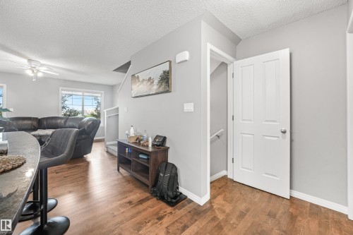 Open concept living area featuring wood-finish flooring, light gray wall tones, and white trim - #40 1030 Chappelle Bv Sw, Edmonton, AB - Indoor