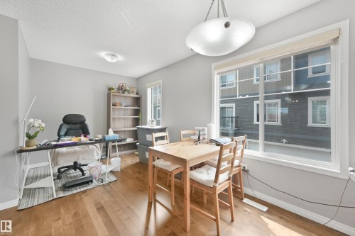 Open-concept room featuring light wood-finish flooring, neutral gray wall paint, and white trim - #40 1030 Chappelle Bv Sw, Edmonton, AB - Indoor