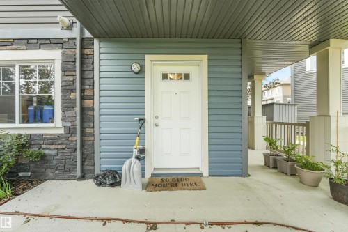 Covered entryway with a white door, horizontal siding, and stone veneer accents - #40 1030 Chappelle Bv Sw, Edmonton, AB - Outdoor