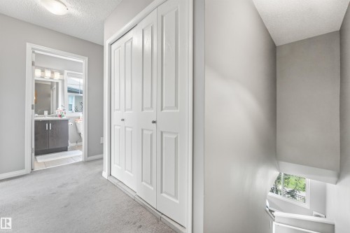 Hallway featuring bifold closet doors and neutral carpeting - #40 1030 Chappelle Bv Sw, Edmonton, AB - Indoor Photo Showing Other Room