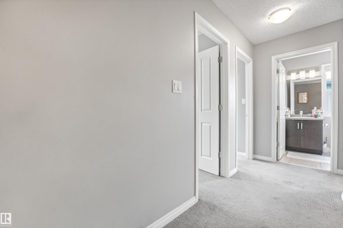Hallway featuring light gray carpeting, white baseboards, and neutral wall paint - #40 1030 Chappelle Bv Sw, Edmonton, AB - Indoor Photo Showing Other Room