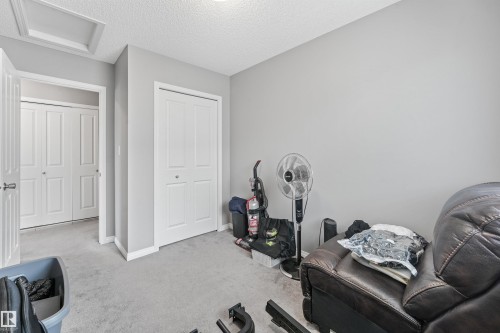 Carpeted room featuring light gray walls, white trim, and white bi-fold closet doors - #40 1030 Chappelle Bv Sw, Edmonton, AB - Indoor