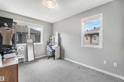 Neutral gray wall paint with white trim, two windows, and light gray carpeting - #40 1030 Chappelle Bv Sw, Edmonton, AB - Indoor