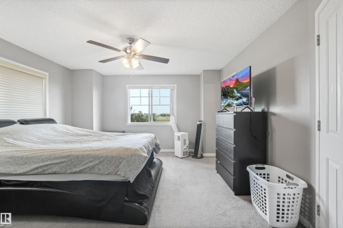 Carpeted bedroom with neutral gray walls and a textured ceiling - #40 1030 Chappelle Bv Sw, Edmonton, AB - Indoor Photo Showing Bedroom