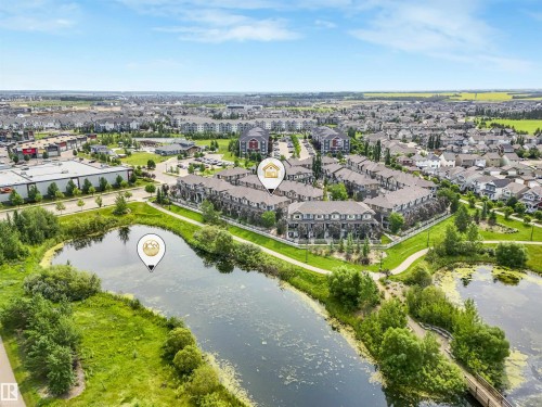 Aerial overview showcasing a residential development with extensive green spaces and two large ponds - #40 1030 Chappelle Bv Sw, Edmonton, AB - Outdoor With Body Of Water With View