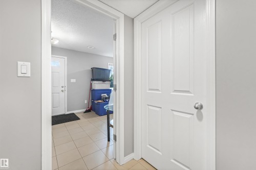 Entryway featuring neutral-toned tile flooring and a light-colored interior door with a silver-finish doorknob - #40 1030 Chappelle Bv Sw, Edmonton, AB - Indoor Photo Showing Other Room