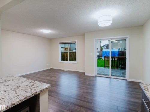 Spacious living area featuring wood-finish flooring, light neutral wall tones, and contemporary ceiling lighting - 5407 14 Avenue Sw, Edmonton, AB - Indoor Photo Showing Living Room