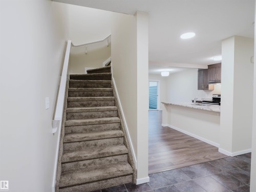 Carpeted staircase with white handrail - 5407 14 Avenue Sw, Edmonton, AB - Indoor Photo Showing Other Room