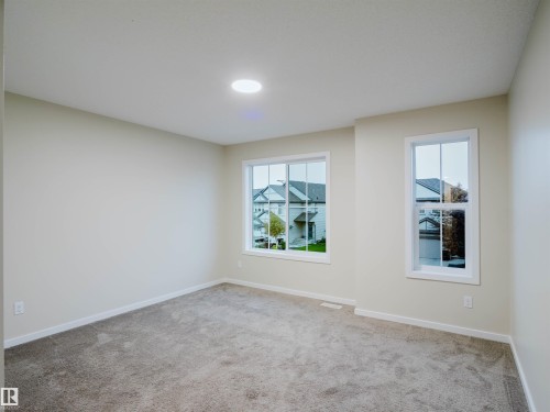 Spacious room featuring neutral carpeting, light-toned walls, and recessed ceiling lighting - 5407 14 Avenue Sw, Edmonton, AB - Indoor Photo Showing Other Room