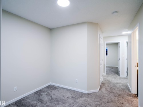 Neutral wall paint and white trim complement the plush gray carpeting throughout this interior space - 5407 14 Avenue Sw, Edmonton, AB - Indoor Photo Showing Other Room