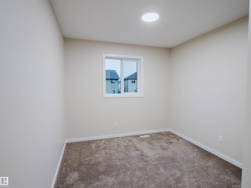 Neutral-toned room featuring a single window, recessed ceiling light, and wall-to-wall carpeting - 5407 14 Avenue Sw, Edmonton, AB - Indoor Photo Showing Other Room