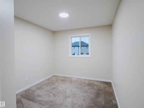Neutral-toned room featuring a single window, recessed ceiling lighting, light-colored walls, and brown carpeting - 5407 14 Avenue Sw, Edmonton, AB - Indoor Photo Showing Other Room