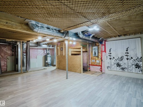 Spacious lower level featuring wood-finish flooring and exposed ceiling beams - 5407 14 Avenue Sw, Edmonton, AB - Indoor Photo Showing Basement