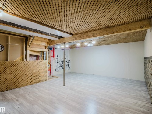 Spacious room featuring wood-finish flooring and a textured wood ceiling - 5407 14 Avenue Sw, Edmonton, AB - Indoor Photo Showing Basement