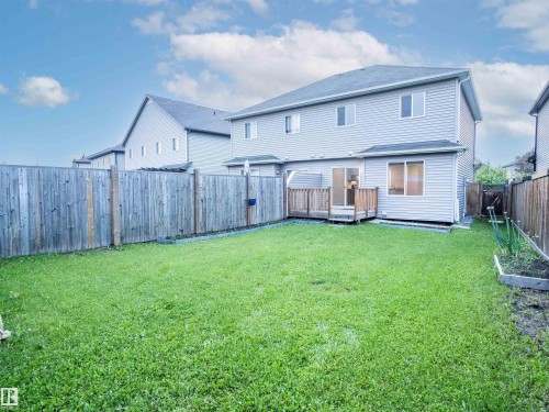 Expansive backyard featuring a manicured lawn, a wooden deck, and full perimeter fencing - 5407 14 Avenue Sw, Edmonton, AB - Outdoor