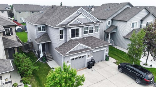 Two-story residence featuring light gray siding, dark shingle roofing, and a prominent front-facing gable - 5407 14 Avenue Sw, Edmonton, AB - Outdoor