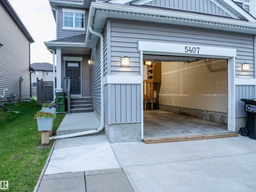 Light gray siding exterior with a front entry porch and an attached garage - 5407 14 Avenue Sw, Edmonton, AB - Outdoor