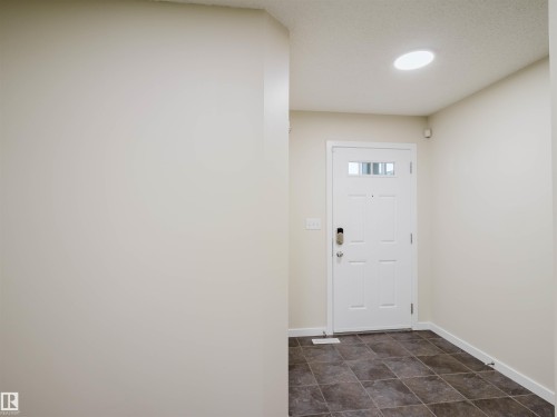 Entryway featuring a white paneled door with glass inserts, square tile flooring, and neutral wall tones - 5407 14 Avenue Sw, Edmonton, AB - Indoor Photo Showing Other Room