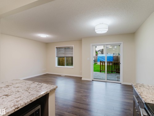 Open concept living space featuring wood-finish flooring, light neutral wall tones, and modern flush-mount lighting fixtures - 5407 14 Avenue Sw, Edmonton, AB - Indoor Photo Showing Living Room