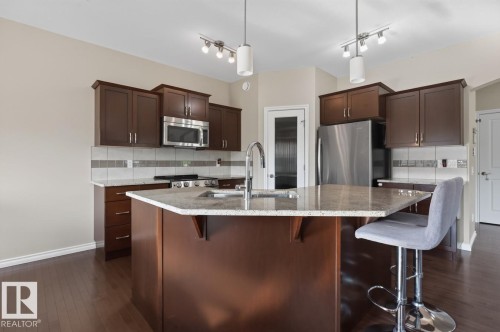 Kitchen featuring a central island with an undermount sink and a gooseneck faucet - 109 Selkirk Place, Leduc, AB - Indoor Photo Showing Kitchen