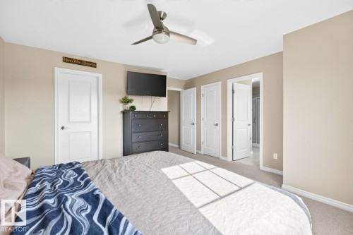 Carpeted room featuring multiple white panel doors, a ceiling fan with integrated lighting, and neutral-toned walls - 109 Selkirk Place, Leduc, AB - Indoor Photo Showing Bedroom