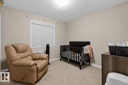 Carpeted room featuring a single window with white blinds, neutral wall paint, white baseboards, and a flush-mount ceiling light - 109 Selkirk Place, Leduc, AB - Indoor Photo Showing Bedroom