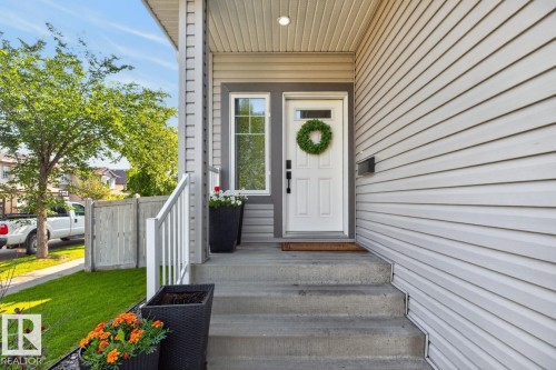 Inviting front entry featuring a white paneled door with transom window, concrete steps, and light-colored horizontal siding - 109 Selkirk Place, Leduc, AB - Outdoor With Exterior