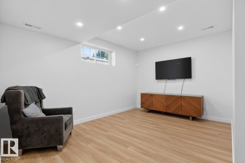 Bright room featuring recessed lighting, wood-finish flooring, and a window providing natural illumination - 109 Selkirk Place, Leduc, AB - Indoor