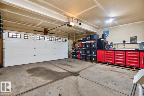 Attached garage featuring a segmented overhead door with multiple window panes and an automatic opener - 109 Selkirk Place, Leduc, AB - Indoor Photo Showing Garage