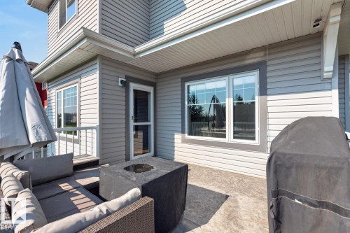 Poured concrete patio featuring light gray siding, white trim, and multiple windows - 109 Selkirk Place, Leduc, AB - Outdoor With Deck Patio Veranda