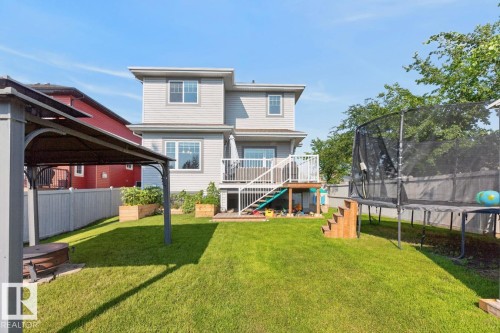 Expansive backyard featuring a manicured lawn, a privacy fence, and multiple raised garden beds - 109 Selkirk Place, Leduc, AB - Outdoor