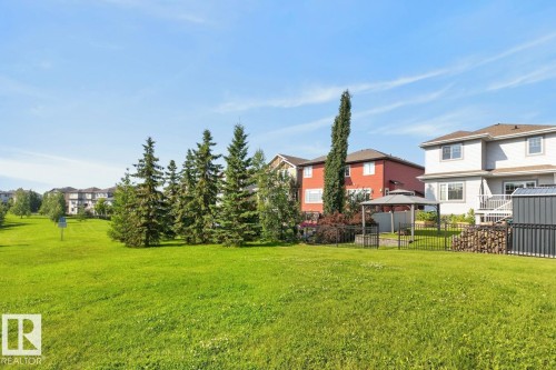 Expansive green space featuring mature evergreen trees and a paved path - 109 Selkirk Place, Leduc, AB - Outdoor With Deck Patio Veranda
