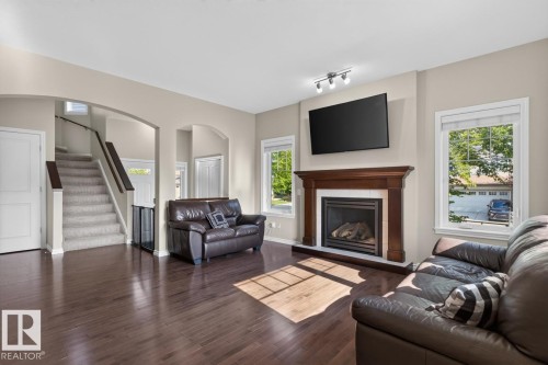 Living area featuring dark wood-finish flooring and a fireplace with a wood mantel - 109 Selkirk Place, Leduc, AB - Indoor Photo Showing Living Room With Fireplace